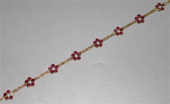 An 18ct and ruby flower head bracelet (1 stone missing), 7in.